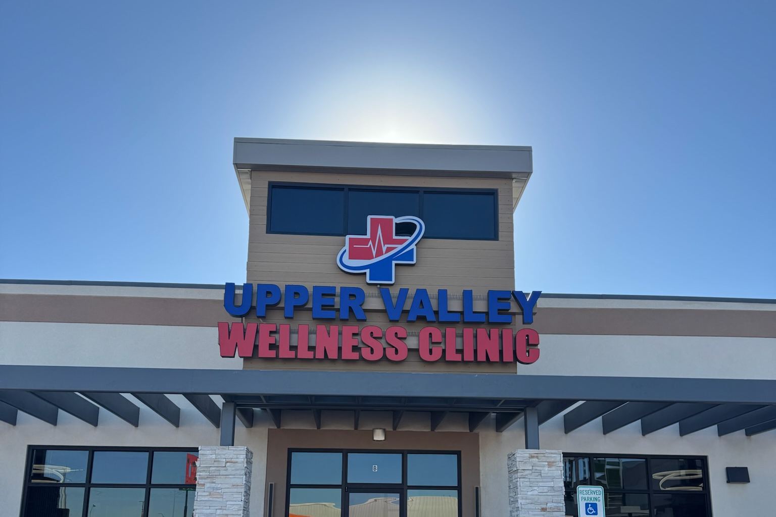 Front of the Upper Valley Wellness Clinic building with its red and blue sign